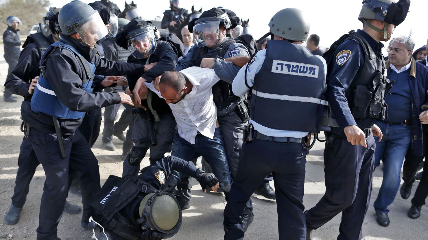 Israeli policemen clash with a Bedouin man following a protest in the Negev Desert on Wednesday.