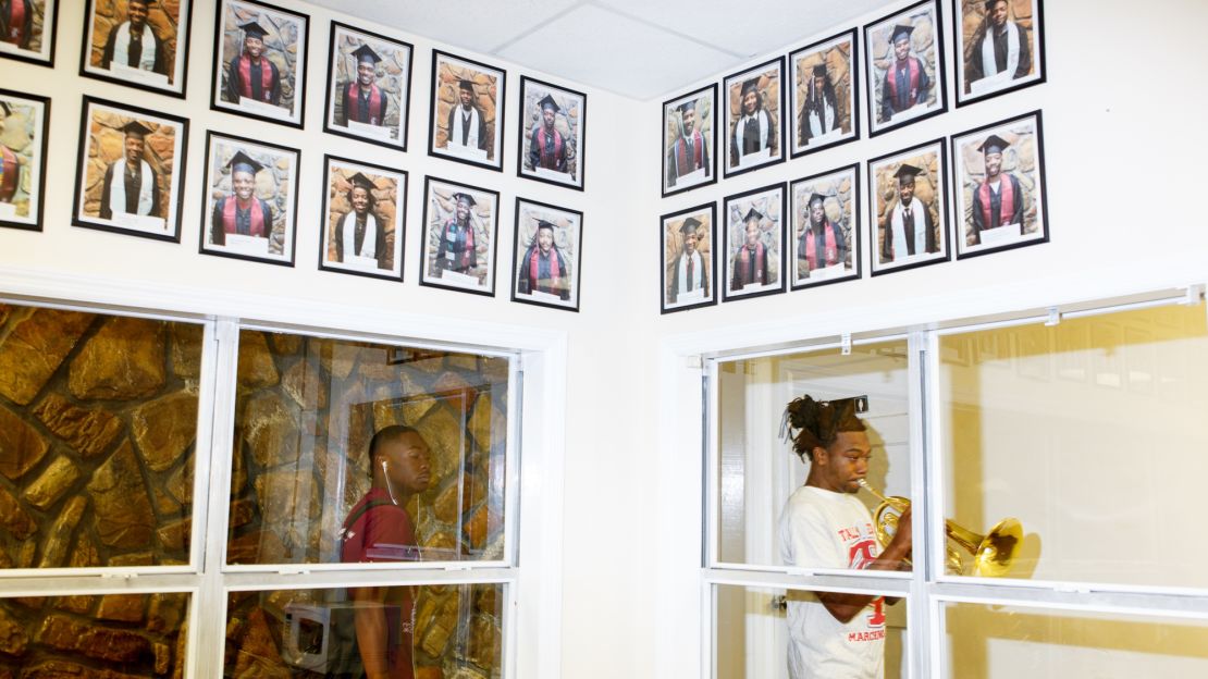 Portraits of graduates line the walls of the band director's office.