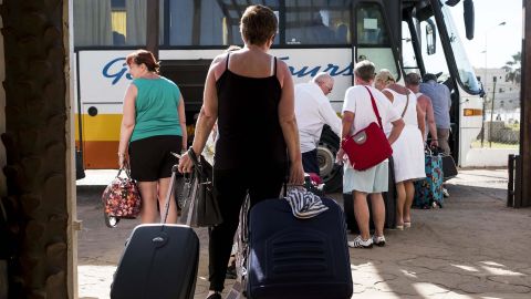 Tourists leave a hotel Wednesday in Banjul after a state of emergency went into effect.