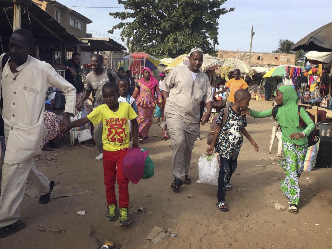 Facing uncertainty, people in Banjul head to a ferry Tuesday destined for Senegal.