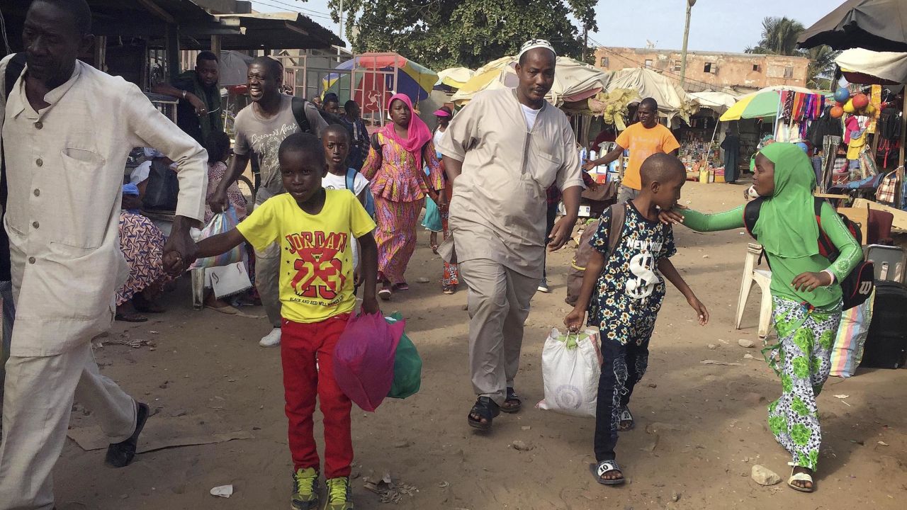 Facing uncertainty at home, people in Banjul, Gambia, head to a ferry this week bound for Senegal.