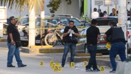 Police investigators work on the crime scene where a shooting erupted after an attack against the building of the Quintana Roo State Prosecution, in Cancun, Mexico, on January 17, 2017. 
The shooting happened as Mexican authorities investigate whether a feud over local drug sales was behind a nightclub shooting that killed three foreigners and two Mexicans Monday at the Blue Parrot club during the BPM electronic music festival in Playa del Carmen, a usually peaceful Caribbean seaside town. / AFP / STR        (Photo credit should read STR/AFP/Getty Images)