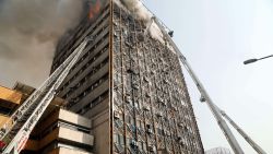 Firefighters battle a blaze that engulfed Iran's oldest high-rise, the 15-storey Plasco building in downtown Tehran on January 19, 2017.
State television said 200 firefighters had been called to the scene and 38 had already been injured battling the blaze before it fell. / AFP / STR        (Photo credit should read STR/AFP/Getty Images)