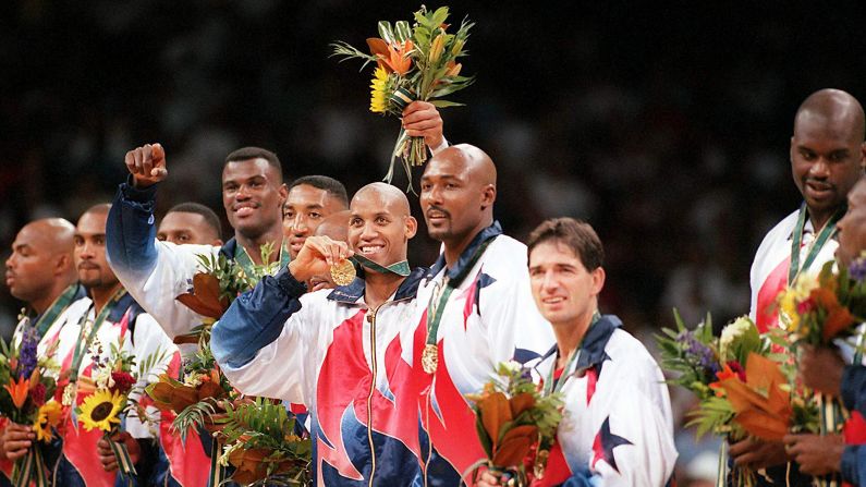 Dream Team member Reggie Miller, center, flashes his gold medal as he stands surrounded by other members of Team USA during the medal presentation in Atlanta's Georgia Dome at the 1996 Summer Olympics. Standing, from left to right, are Charles Barkley, Grant Hill, Penny Hardaway, David Robinson, Scottie Pippen, Miller, Karl Malone, John Stockton and Shaquille O'Neal.