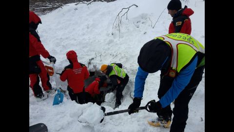 Rescuers dig for avalanche survivors after skiing several kilometers through blizzard conditions to reach the hotel, on January 19.