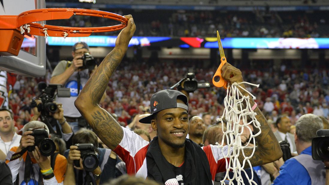 Kevin Ware of the Louisville Cardinals cuts the net after his team defeated Michigan 82-76 in the NCAA men's basketball championship game in April 2013.