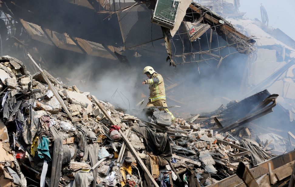 A firefighter climbs over the fallen wreckage of the Plasco building. Thirty-five firefighters are missing after the multi-story building collapsed around them as they battled a blaze, Tehran Fire Department spokesman Jalal Maleki told a local journalist on the scene. Rescue teams are trying to dig out the missing firefighters, Maleki said.
