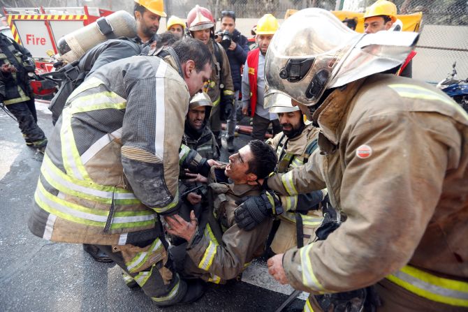 Iranian firefighters comfort a fellow fireman in the aftermath of the building collapse.