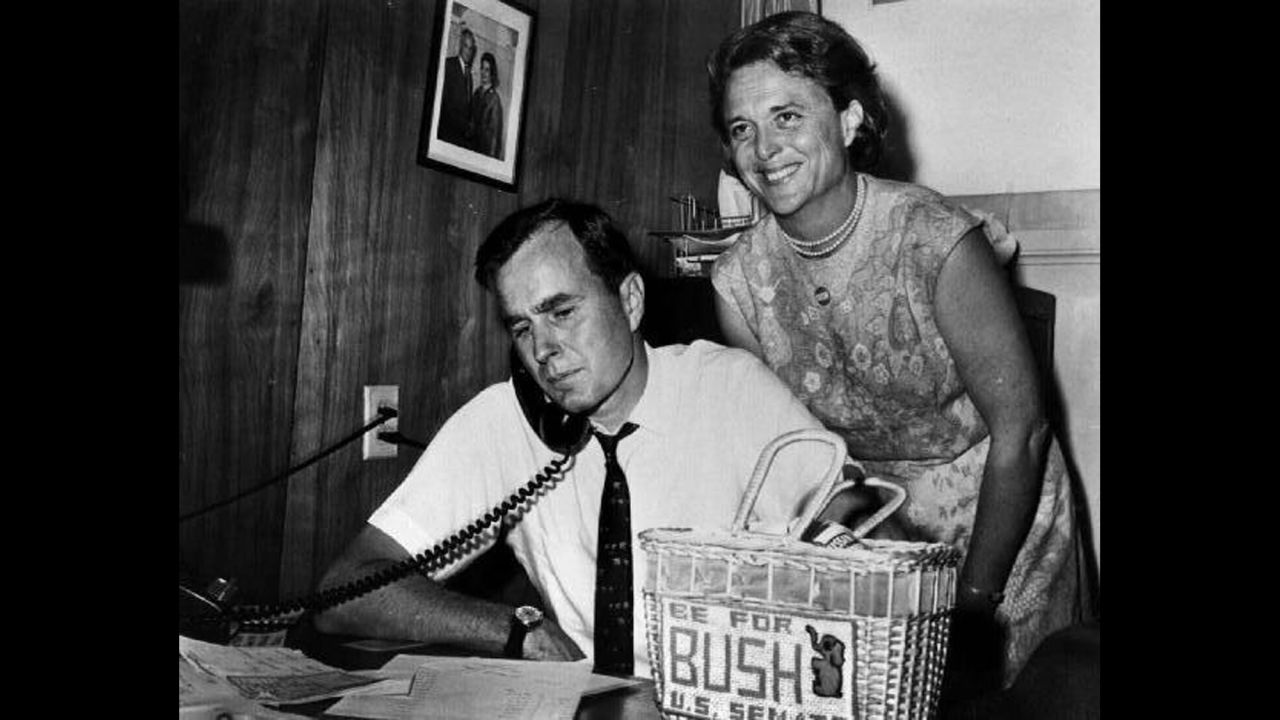 Bush with her husband as he campaigns for the US Senate in 1964. On the desk is a needlepoint bag she made.