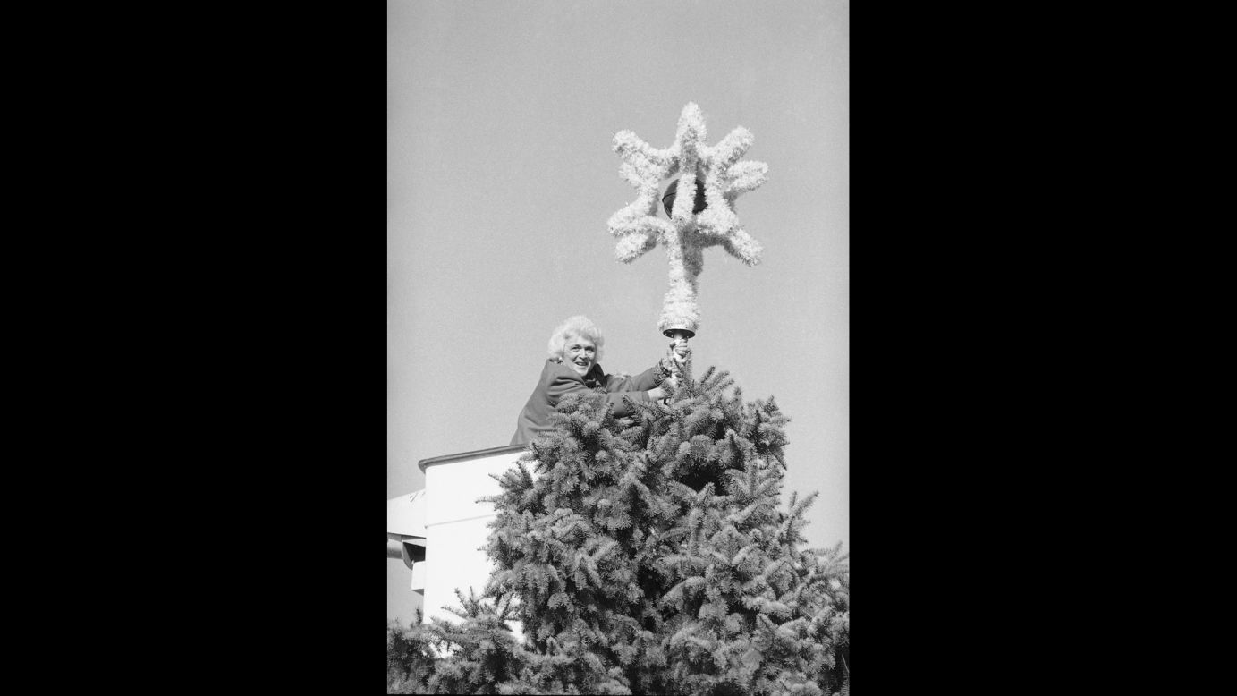 Bush places an ornament atop the National Christmas Tree in Washington on November 30, 1983.