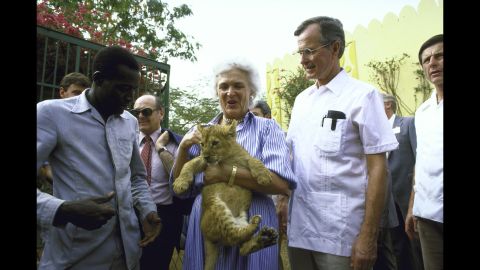 Bush holds a lion cub while she and her husband visit a garden project in 1985.