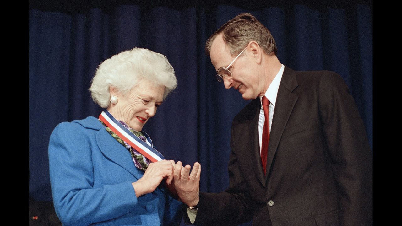 President Bush admires the Harry S. Truman Award for Distinguished Service that his wife received in Washington on March 30, 1989.