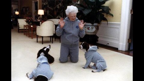 Bush and her dogs, Ranger and Millie, wear matching gray sweatsuits at the White House on January 9, 1991.