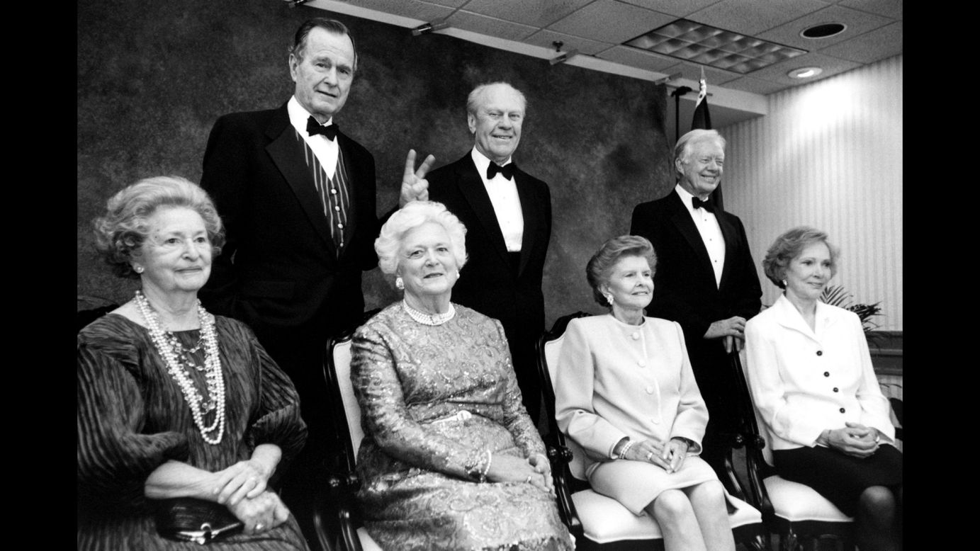 President Bush gives his wife "bunny ears" during an event at the Gerald R. Ford Library on April 16, 1997. Also pictured are former Presidents Ford and Jimmy Carter, as well as former first ladies Lady Bird Johnson, Betty Ford and Rosalynn Carter.