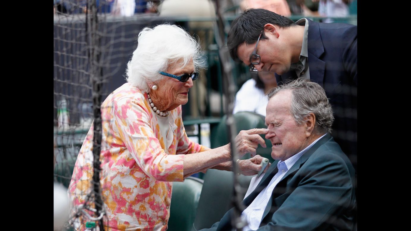 Barbara Bush puts some sunscreen on her husband's nose as they get ready to watch the Seattle Mariners play the Houston Astros in a Major League Baseball game on May 3, 2015.