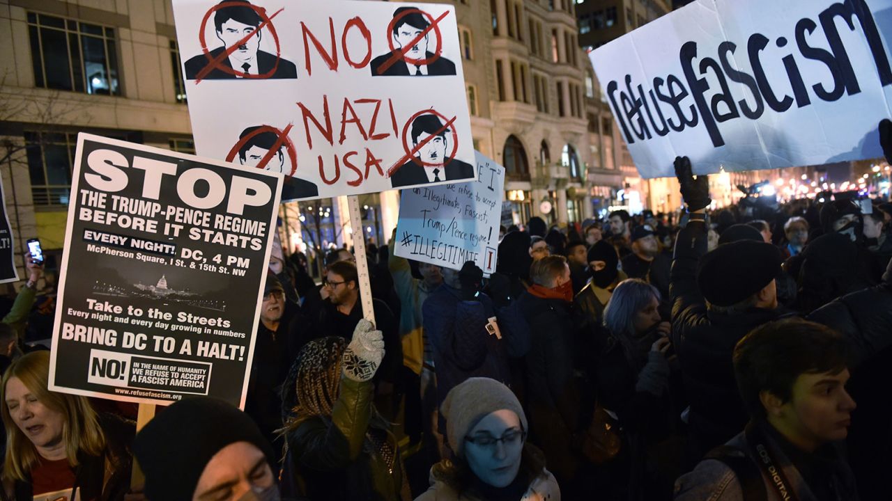 Activists hold up signs during a Deplorable ball protest in a street outside press club in Washington, DC on January 19, 2017.  