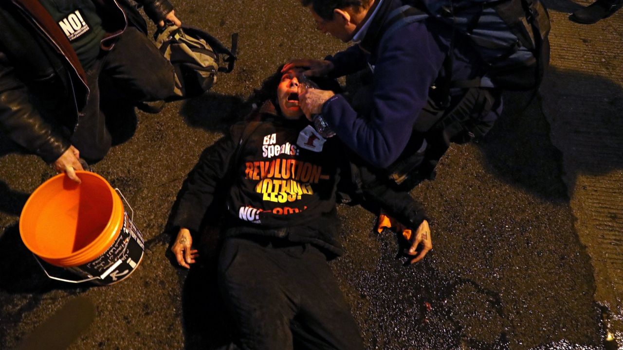 A protester has her eyes flushed with water.