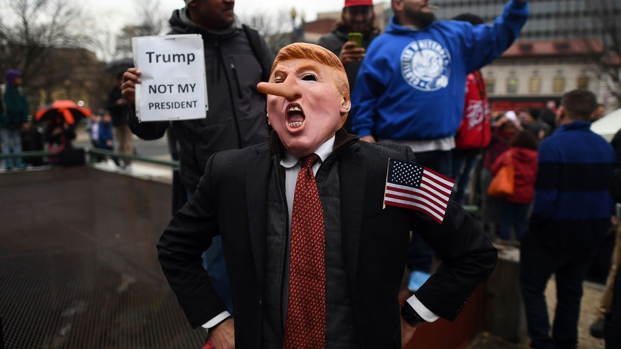 Demonstrators protest against US President-elect Donald Trump before his inauguration on January 20, 2017, in Washington, DC.
