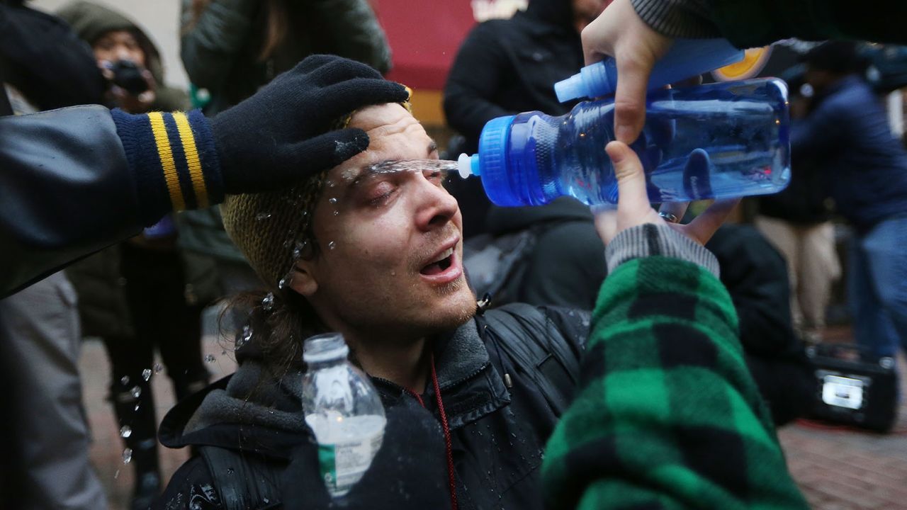 A man is washed with water after being sprayed by police pepper spray during an anti-Trump demonstration on January 20, 2017 in Washington, DC.