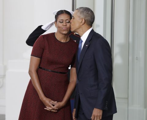President Obama kisses the first lady as they await the arrival of President-elect Trump and his wife, Melania.