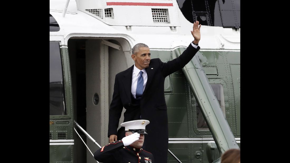 Former President Barack Obama waves as he boards a Marine helicopter during a departure ceremony.