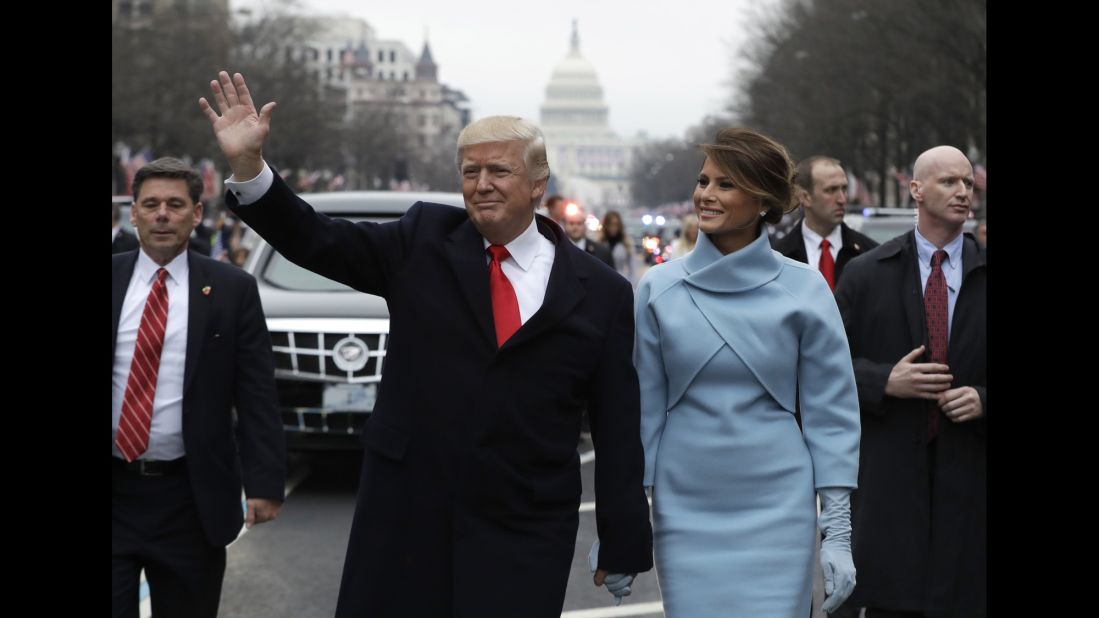 President Donald Trump waves as he walks on Pennsylvania Avenue with first lady Melania Trump during the Presidential Inaugural Parade on Friday, January 20.
