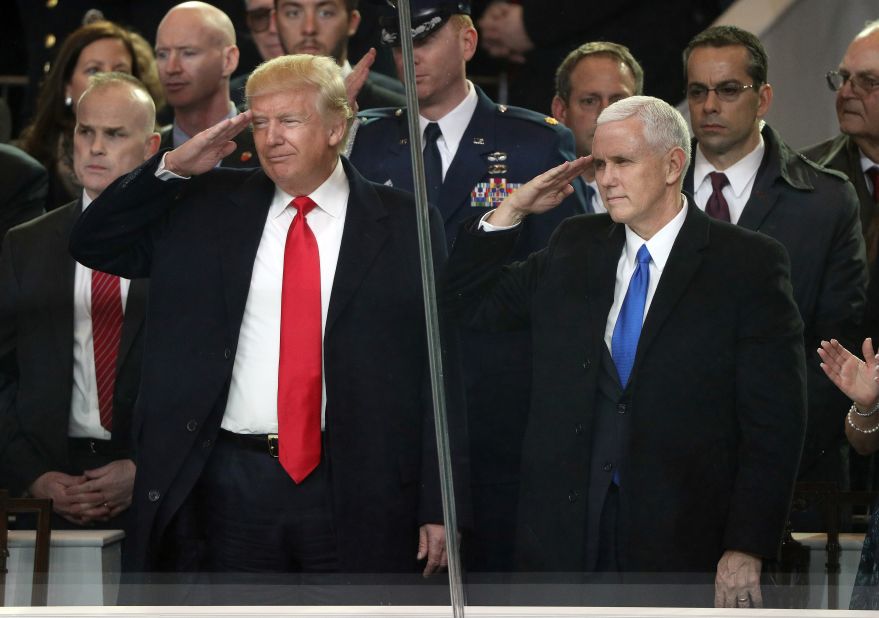 President Donald Trump and Vice President Mike Pence salute military personnel from the main reviewing stand in front of the White House during the Presidential Inaugural Parade.