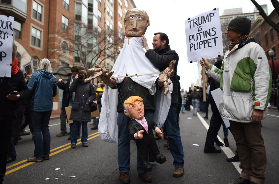 Protesters march with puppets depicting Trump and  Russian President Vladimir Putin. 