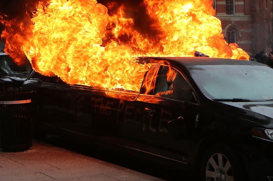 Flames erupt from a limousine after windows were smashed.