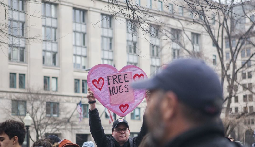 A man holds a sign offering free hugs during the protests. 