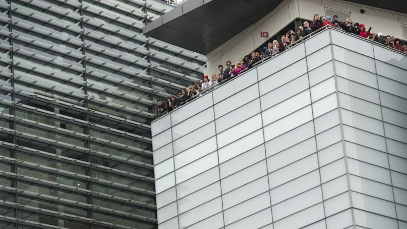 Spectators watch from rooftops as President Donald Trump and first lady Melania Trump walk in the inaugural parade on Friday, January 20, in Washington.