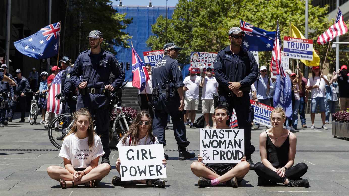 Protesters sit in front of police separating them from a small pro-Trump rally in Sydney.