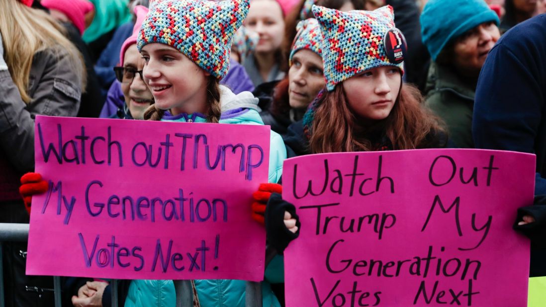 Girls hold anti-Trump signs during the march.