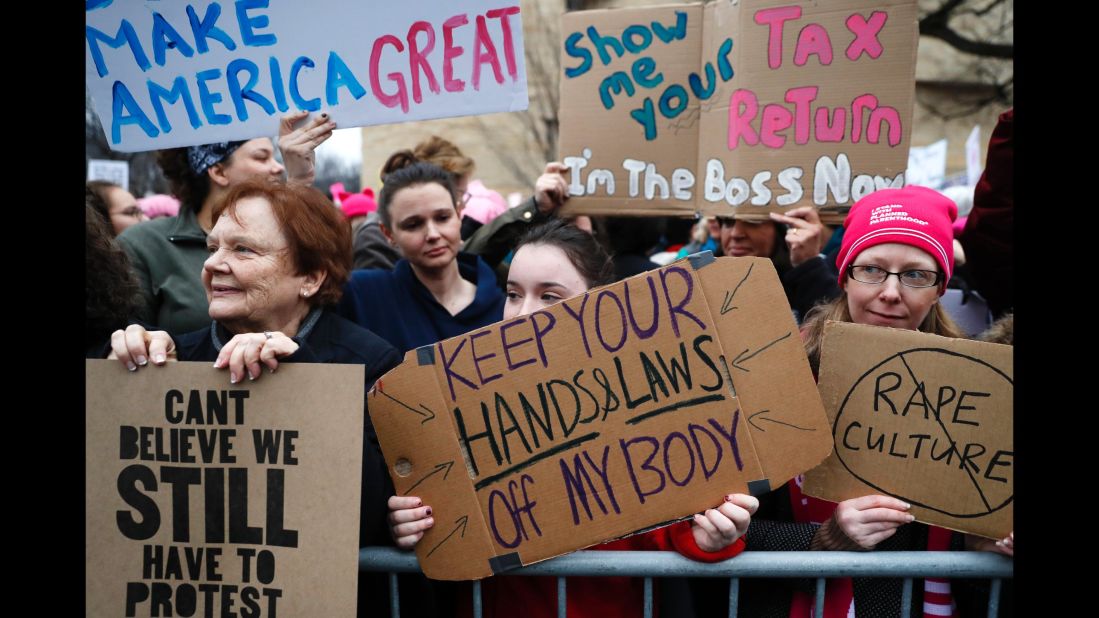 Lily Donahue of Wappingers Falls, New York, center, is among the thousands with signs protesting violence against women.