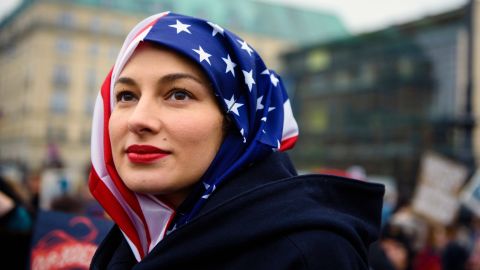 A woman wears a US flag like a hijab during a protest of US Democrats Abroad in front of the Brandenburg Gate in Berlin on January 21, 2017, one day after the inauguration of the US President. 