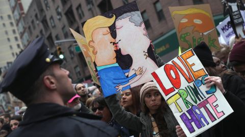 People hold up a drawing of Donald Trump and Vladimir Putin kissing while taking  of part in the Women's March on January 21, 2017 in New York City. The Midtown Manhattan event was one of many anti-Trump protests nationwide that came a day after Donald Trump was sworn in as the 45th President of the United States. 