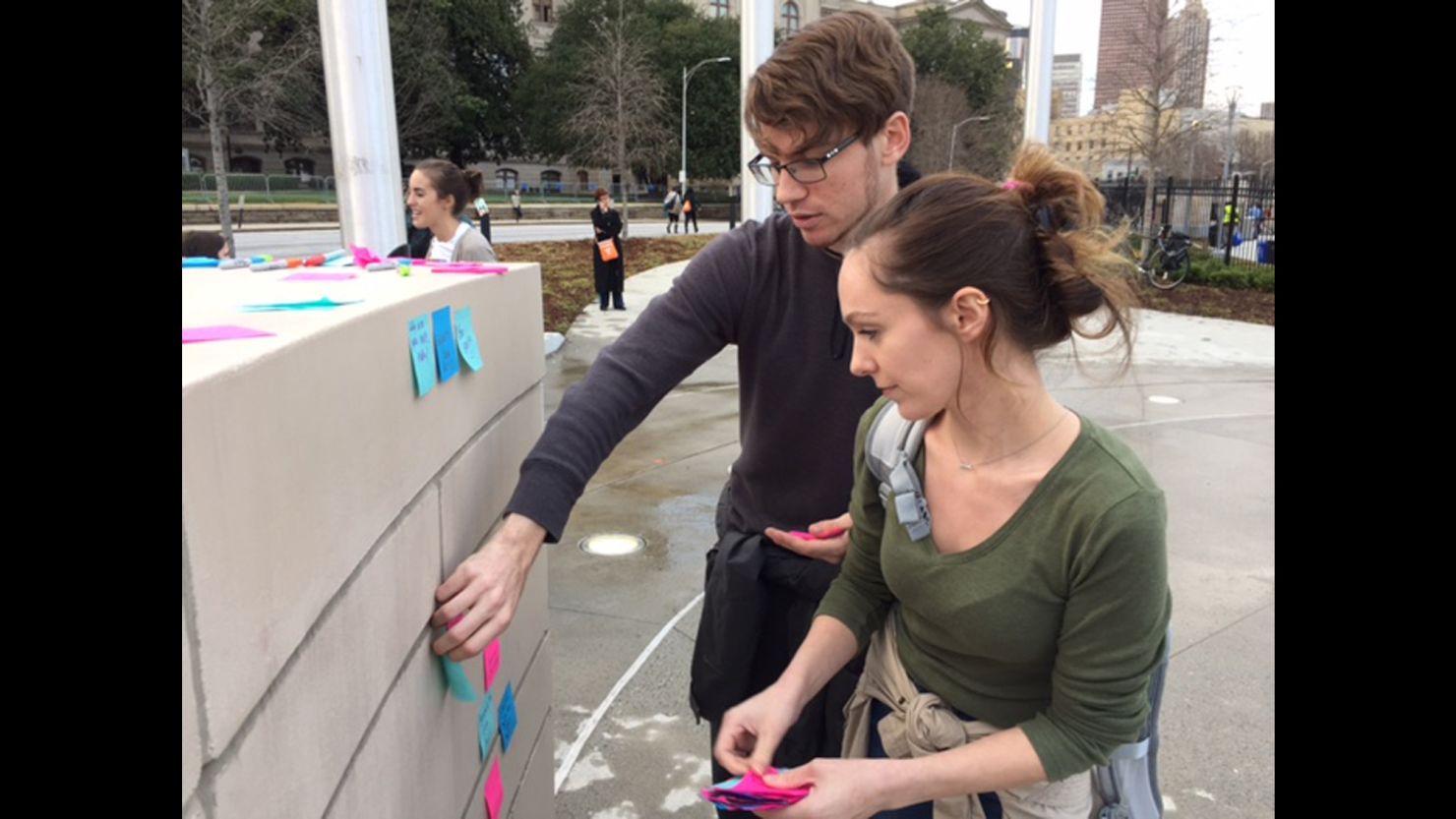 Dylan Stone-Miller and his girlfriend, Andrea McGrath, stand at a wall near the Georgia state Capitol.