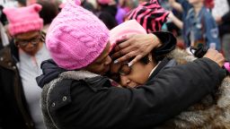 A mother embraces her daughter during the Women's March on January 21, 2017 in Washington, DC. Hundreds of thousands of people flooded US cities Saturday in a day of women's rights protests to mark President Donald Trump's first full day in office. 