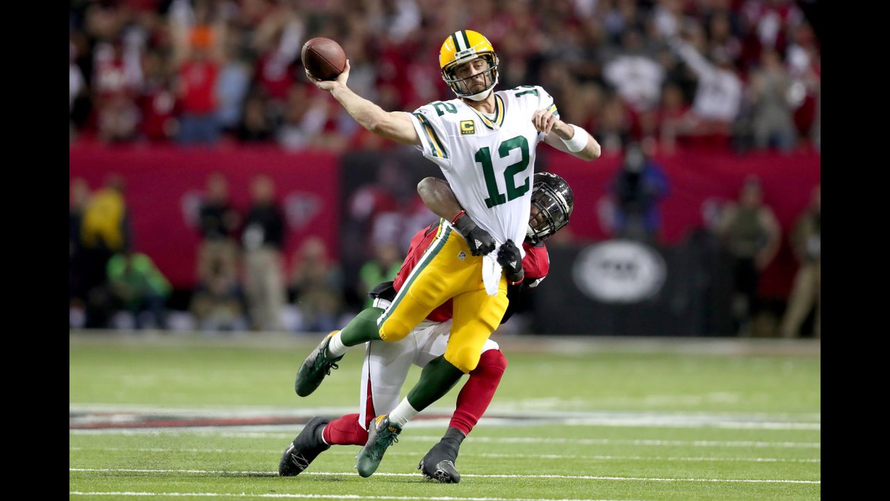 Packers quarterback Aaron Rodgers throws as he is hit by Falcons linebacker Deion Jones in the first quarter.
