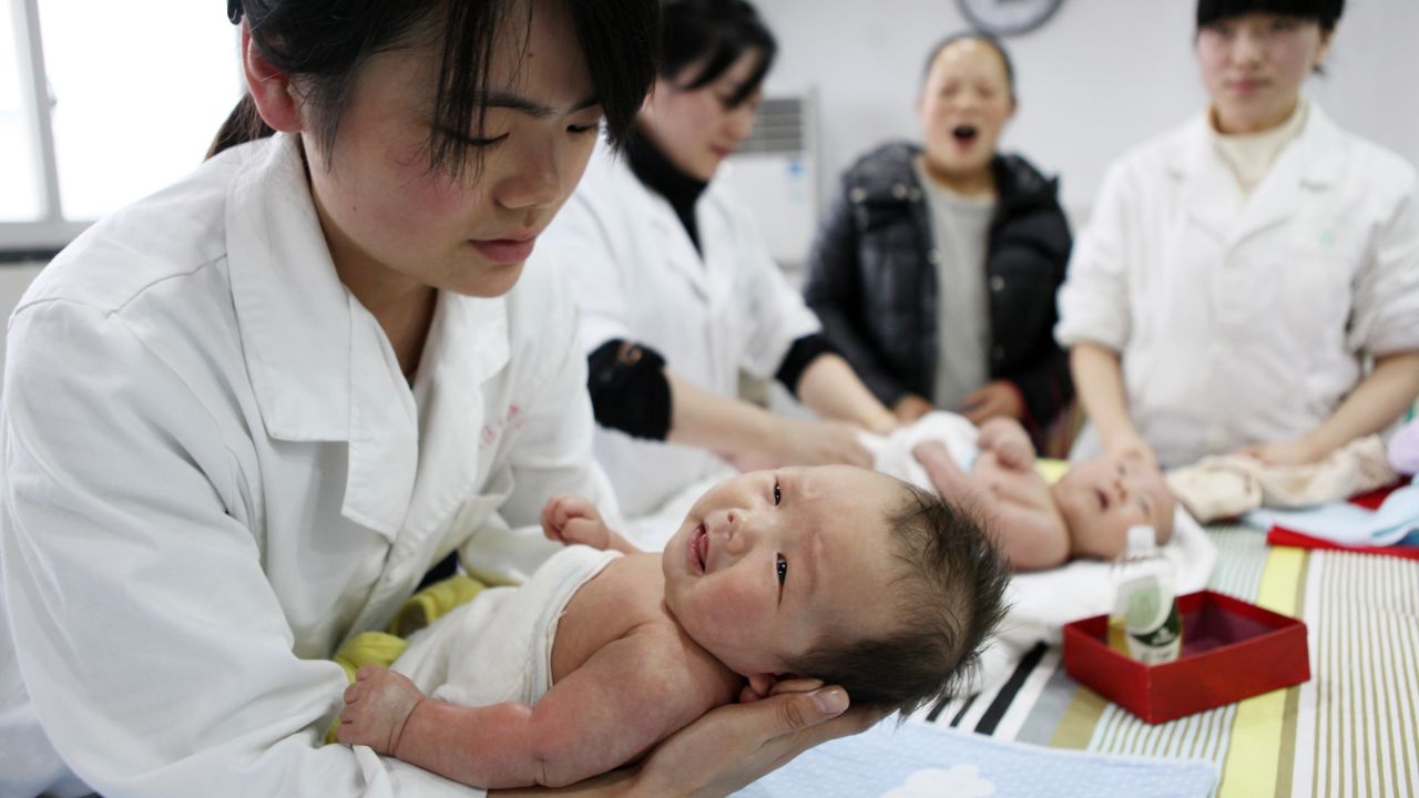 A nurse holds a baby at an infant care center in Yongquan,  southwest China, in 2015.