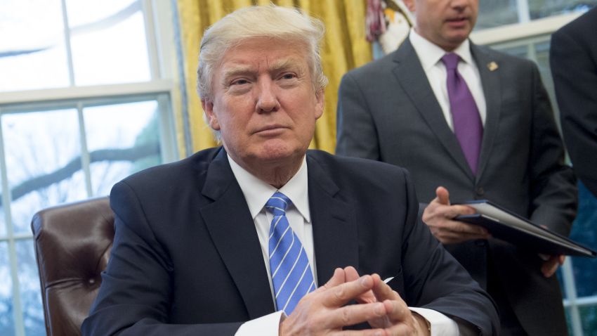 President Donald Trump prepares to sign several executive orders in the Oval Office of the White House in Washington, DC, January 23, 2017.