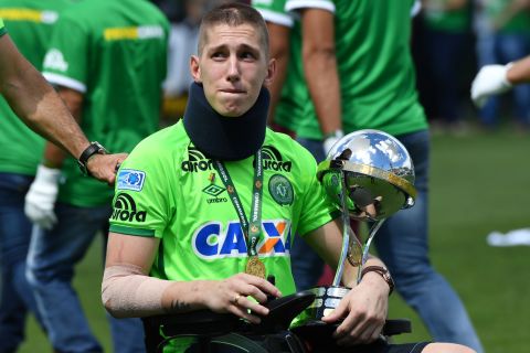 Goalkeeper Jackson Follmann holds the Copa Sudamericana trophy that was awarded to Chapecoense in the aftermath of the disaster by CONMEBOL, South American soccer's governing body. He had to have his leg amputated after surviving the crash.