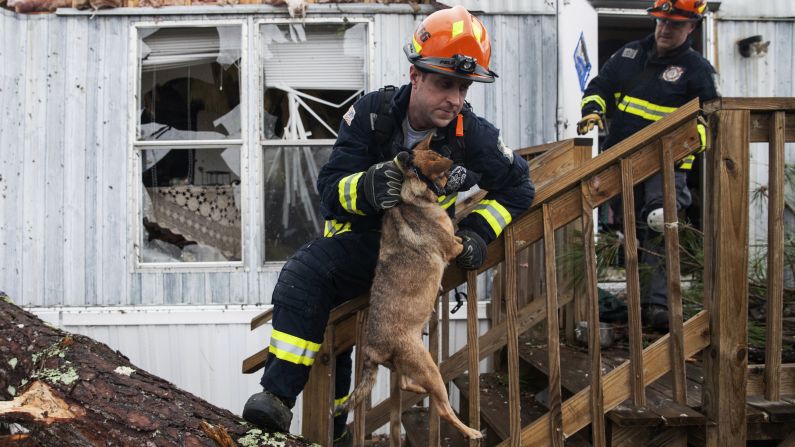 A firefighter carries a dog that was trapped inside a mobile home in Albany, Georgia, on Monday, January 23. Fire and rescue crews have been searching through the debris after <a href="index.php?page=&url=http%3A%2F%2Fwww.cnn.com%2F2017%2F01%2F23%2Fus%2Fsevere-weather%2Findex.html" target="_blank">severe storms</a> hit southern Georgia over the weekend.