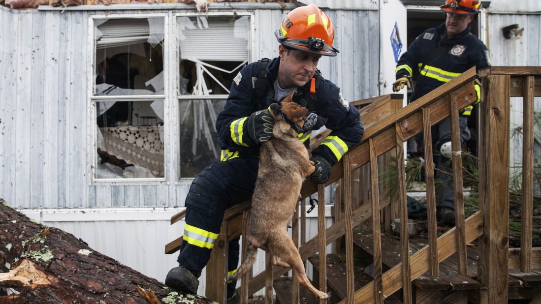 A firefighter carries a dog that was trapped inside a mobile home in Albany, Georgia, on Monday, January 23. Fire and rescue crews have been searching through the debris after <a href="http://www.cnn.com/2017/01/23/us/severe-weather/index.html" target="_blank">severe storms</a> hit southern Georgia over the weekend.