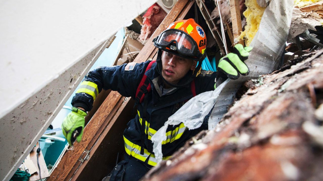 A rescue worker searches inside a mobile home in Albany on January 23.