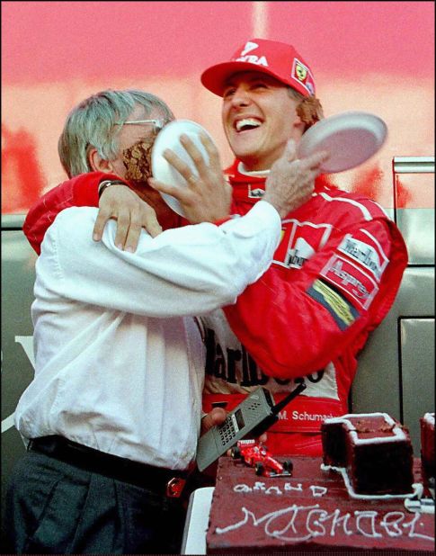 Ecclestone gets a taste of Michael Schumacher's 100-race anniversary cake. 