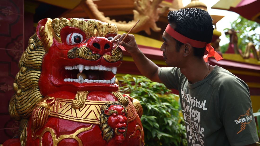 A worker paints a statue at a temple in Denpasar, Indonesia, on Monday, January 23.