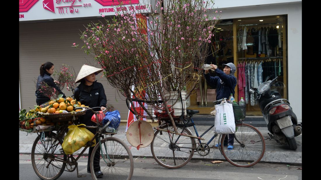 Vendors sell peach blossoms along a street in Hanoi, Vietnam, on Monday, January 23.