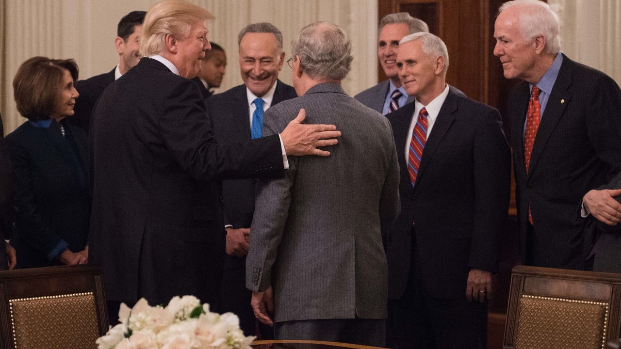 In this January 23, 2017, file photo, President Donald Trump speaks with Senate Majority Leader Mitch McConnell (L) as House Minority Leader Nancy Pelosi (L), Senate Minority Leader Chuck Schumer (3rd L), House Majority Leader Kevin McCarthy (3rd R), Vice President Mike Pence (2nd L) and Senate Majority Whip John Cornyn (R) look on.