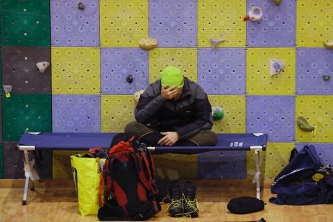 A rescuer rests at a sports complex turned emergency coordination center in Penne on January 21.